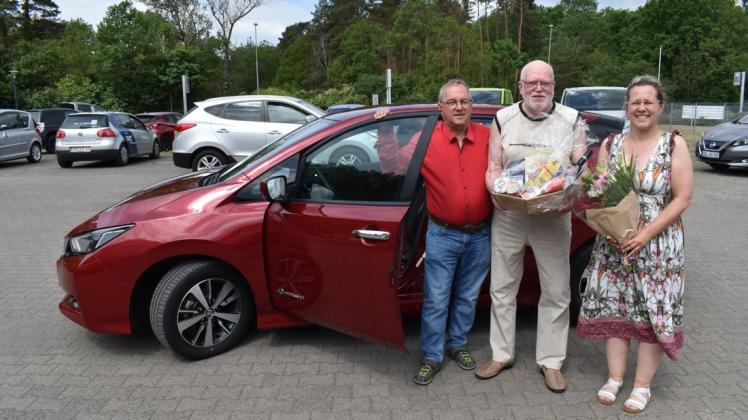 Jenny und Horst Gläss gratulieren ihrem Stammkunden Siegfried Jacobsen zum Kauf eines neuen E-Autos.