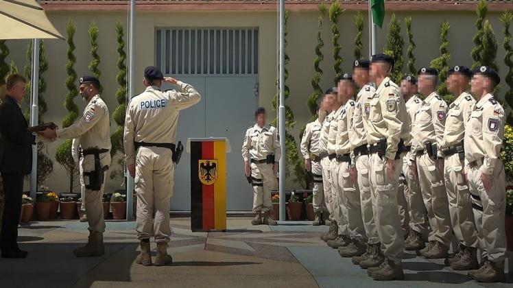 Die deutsche Fahne wird in Kabul eingeholt und von Polizeihauptmeister Steward-Lee Dieter an den Botschafter übergeben.