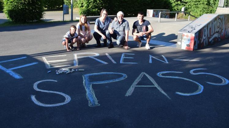 Perry (7), Rieke (13), Susanne und Manfred Ahrens sowie Sarmand (17) haben „Ferienspass“ mit Straßenkreide auf den Asphalt geschrieben.