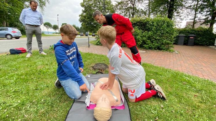 Unter den Augen von Vereinspräsident Bodo Arndt und Notfallarzt Andreas Atzeni versuchen sich die Nachwuchskicker Finlay Hoff und Lenny Rietenbach am Thorax einer Übungspuppe in der Laienreanimation.
