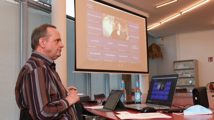 Bürgervorsteher Uwe Runge sitzt als einziger Kommunalpolitiker während der digitalen Debatte im Rathaus, vor sich unter anderem ein iPad mit den Unterlagen für die Sitzung.