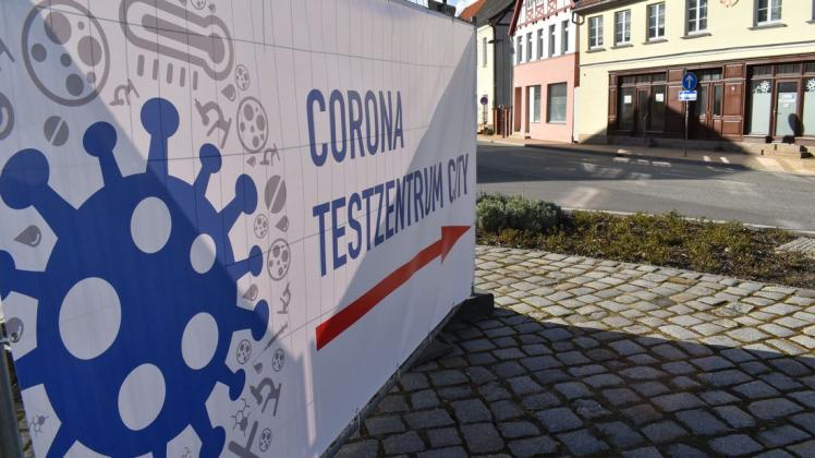 Mit eine großen Plakat wird in der Einkaufsstraße von Bützow auf das Corona-Testzentrum hingewiesen.