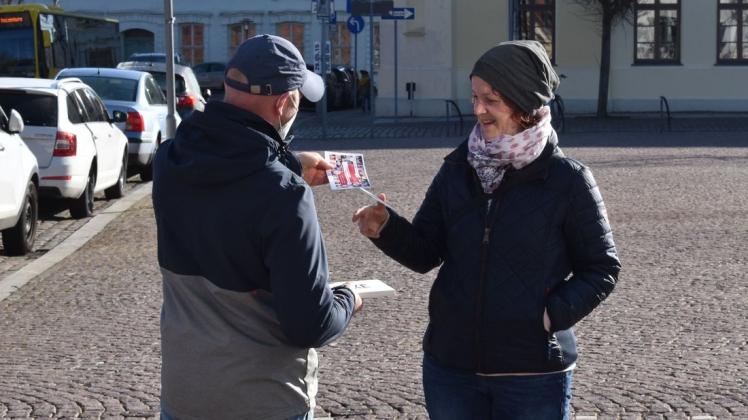 Christan Hameister (l.) verteilt Danke-Karten auf dem Boizenburger Markt und erntet ein Lächeln dafür.