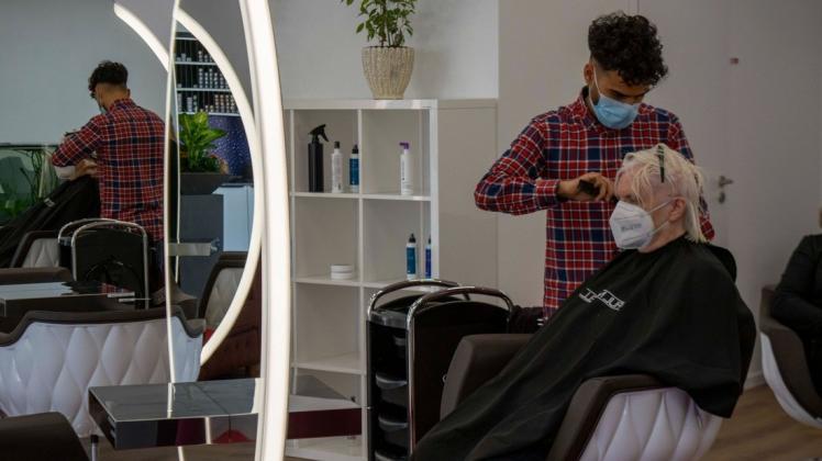 Friseur und Fußballer Ömer-Faruk Kalmis hat sich selbstständig gemacht. Mit seinem Salon "Kalmis Hair & Beauty" ist er in die ehemaligen Räumlichkeiten von Musikhaus Spula gezogen. Kundin Christa Gau freut sich, dass sie sich nach so langer Phase des Lockdowns endlich wieder die Haare schneiden lassen kann.