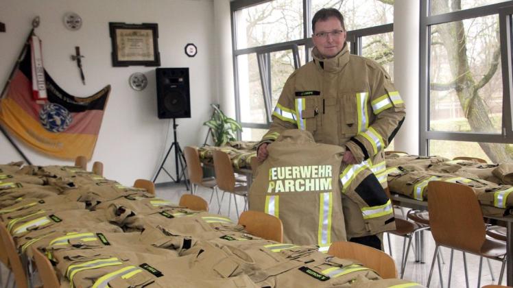 Gerätewart Jörg Lampe präsentiert die neue sandfarbene Einsatzkleidung der Parchimer Feuerwehr.