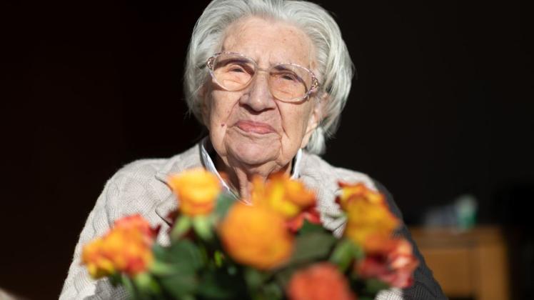 Mina Hehn hat an ihrem 108. Geburtstag in ihrem Terasseneingang in einem Pflegeheim einen Blumenstrauß auf dem Schoß.