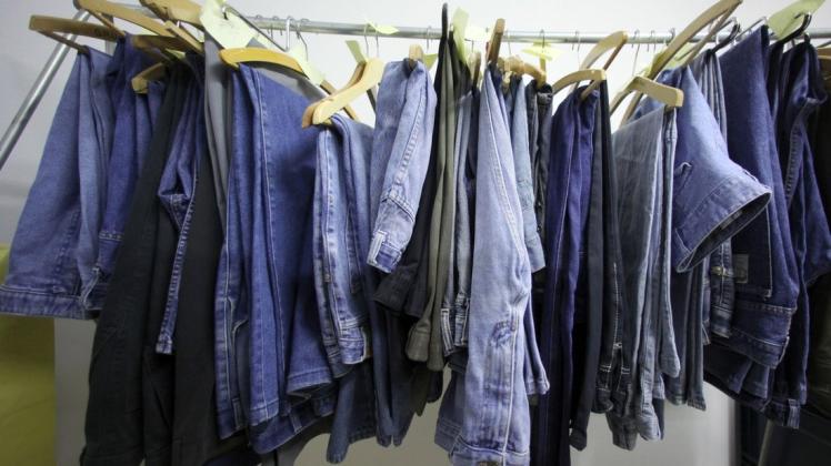 Jeans für Herren hängen in einer Kleiderkammer. (Symbolbild)