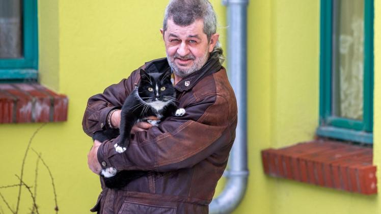 Torsten Lohr und der sechs Jahre alte Kater Quarky im Innenhof eines Wohnhauses : Jetzt will die Katze eine Stiftung gründen - ganz wie die Landesregierung.  Foto: Jens Büttner/dpa-Zentralbild/dpa +++ dpa-Bildfunk +++