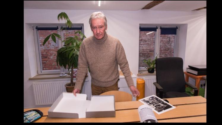 Gerhard Stromberg sortiert in seinem  Atelier Vorlagen für Banner und Probedrucke für den Katalog.