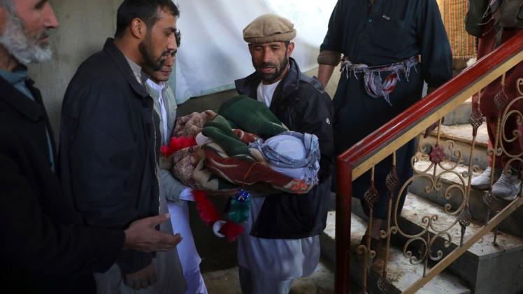 Die Kehrseite boomender Rüstungsgeschäfte: Männer tragen die Leiche eines Jungen, der bei einem Raketenangriff in der afghanischen Hauptstadt Kabul getötet wurde.
