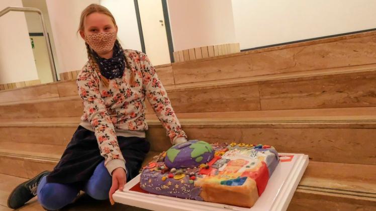 Links die Weltkugel, rechts das Sieger-Motiv: Gewinnerin Lisa-Marie Meyer posiert vorbildlich mit Torte und Corona-Schutzmaske.
Foto: Thomas Osterfeld Links die Weltkugel, rechts das Sieger-Motiv: Gewinnerin Lisa-Marie Meyer posiert vorbildlich mit Torte und Corona-Schutzmaske.
Foto: Thomas Osterfeld
