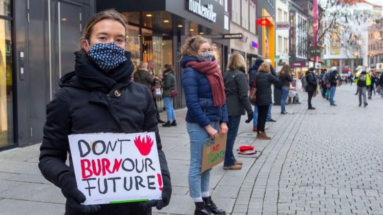 "Don&apos;t burn our future" (Verbrennt nicht unsere Zukunft): Mit Schildern wie diesen setzten sich Teilnehmer einer Menschenkette am Freitag in Osnabrück für einen besseren Klimaschutz ein.