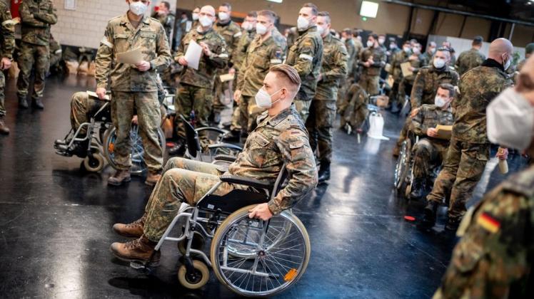 Bundeswehrsoldaten, teils in Rollstühlen, dienen als Statisten auf den Start eines Testlaufs im Berliner Corona-Impfzentrum in Treptow.