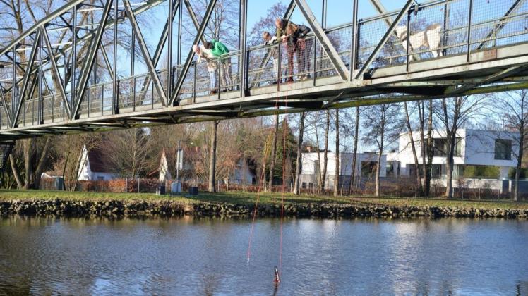 Gemeinsam ziehen die Kinder Mia und Tim Vedder zusammen mit Udo Ernst ein Fahrrad aus dem Kanal. Spaziergänger schauen interessiert zu. Gemeinsam ziehen die Kinder Mia und Tim Vedder zusammen mit Udo Ernst ein Fahrrad aus dem Kanal. Spaziergänger schauen interessiert zu.