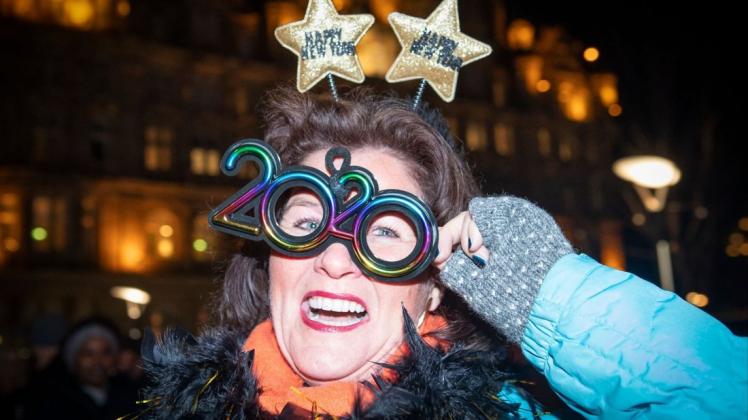 Da war noch alles in Ordnung und 2020 ein Jahr wie jedes andere: Marieke Van&apos;t Riet, aus Amsterdam, nimmt am Straßenfestes in der Princes Street während der Hogmanay Neujahrsfeier teil und trägt eine Brille mit der Jahreszahl 2020. Foto: Jane Barlow/dpa