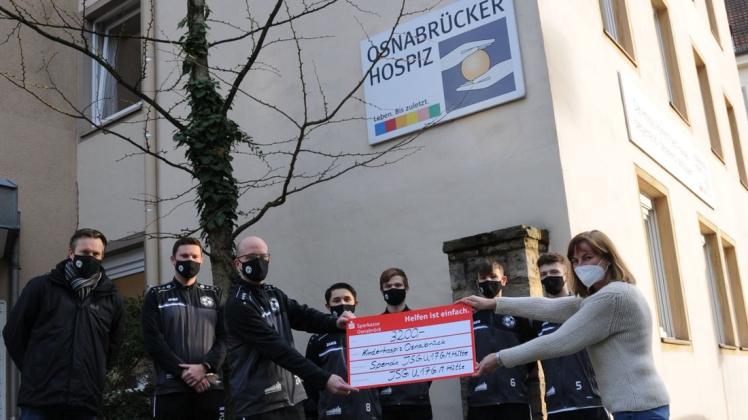Scheck über 3200 Euro: Beeindruckte Gesichter vor dem Osnabrücker Hospiz.