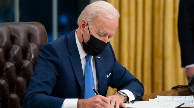 US-Präsident Joe Biden unterzeichnet eine verfügung im Oval Office des Weißen Hauses.