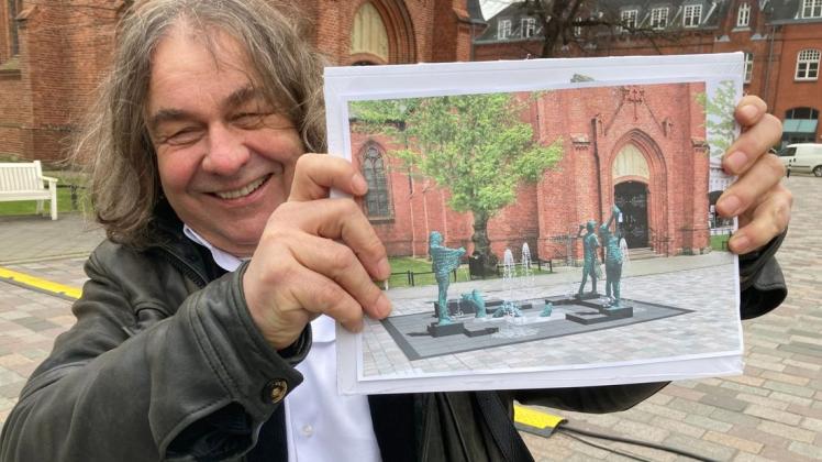 Bildhauer Thomas Jastram mit einer Fotomontage seines Neptunbrunnens für den Warnemünder Kirchenplatz. Wenn die 150.000 Euro an Spenden zuammenkommen, kann er 2022 stehen.