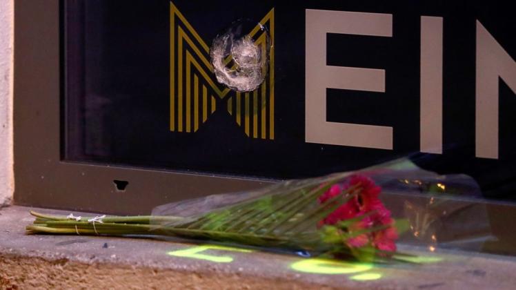 Blumen liegen unter einem Einschussloch in einer Scheibe im Bereich des Tatorts der Terror-Attacke in der Nähe der Hauptsynagoge in Wien.