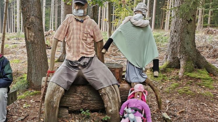 Die Kleidung der Holzfiguren im Driehauser/Krebsburger Wald wechselt je nach Jahreszeit. Zu Corona-Zeiten ist ein Mundschutz Pflicht.