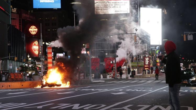 Während Trump spricht, legen Aktivisten am News Yorker Times Square Feuer.
