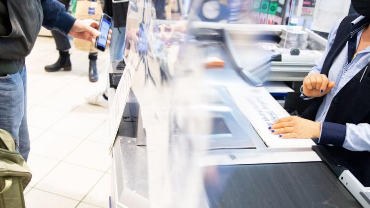 Zwischen Heldin des Alltags und Opfer für coronagetriebene Aggression: Kassiererin im Supermarkt (Symbolfoto). Zwischen Heldin des Alltags und Opfer für coronagetriebene Aggression: Kassiererin im Supermarkt (Symbolfoto).