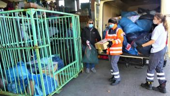 Der Sanitätskraftwagen muss von drei DRK-Helferinnen entladen werden – sieben große Gitterboxen wurden mit den eingesammelten Altkleidern aus den 31 Ortschaften im Altkreis Wittlage gefüllt, gut 3,5 Tonnen Sammelgut.