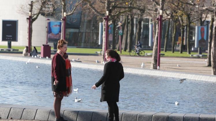 Zwei Frauen unterhalten sich in Amsterdam und halten Sicherheitsabstand.