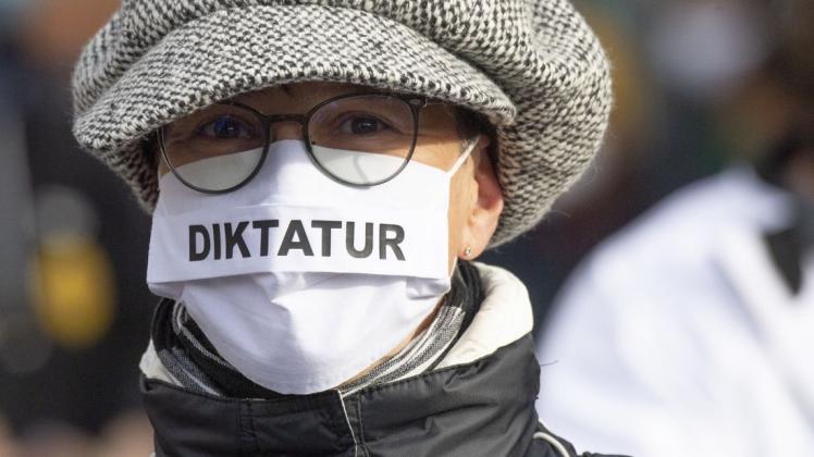 Alles schon wie in der DDR?  "Diktatur" steht auf der Nase-Mund-Bedeckung einer Teilnehmerin an einer "Querdenken"-Demonstration.