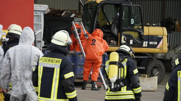 In orangefarbene Schutzanzüge gehüllt kümmerten sich zwei Feuerwehrleute um die gefährliche Flüssigkeit.