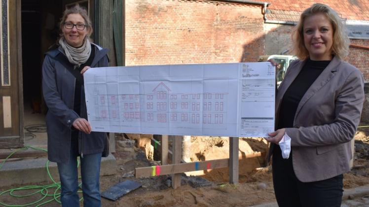 So soll das neue Verwaltungsgebäude in Grabow aussehen. Bürgermeisterin Kathleen Bartels (r.) und Planerin Annett Ohm präsentieren die zukünftige Ansicht von der Kirchenstraße aus.