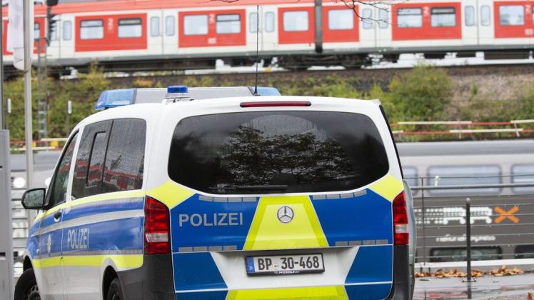 Ein Polizeiauto steht bei der Lanxess Arena. Im Hintergrund sind Züge auf dem Gelände des DB Betriebsbahnhofs Deutzer Feld zu sehen.