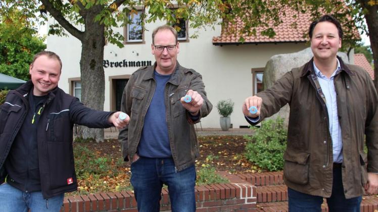Auch ohne Kirmes soll es ein bisschen bunt werden in Remsede: Auf den Verkauf vieler Buttons hoffen Lukas Eckelkamp, Ortsbürgermeister Christoph Rosemann und Bürgermeister Tobias Avermann.