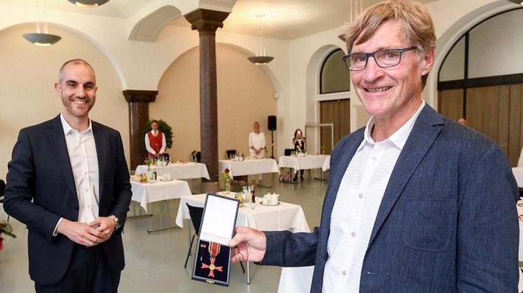 Oberbürgermeister Belit Onay (links) überreichte das Bundesverdienstkreuz an Wolfgang Pruisken.