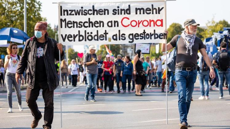 "Inzwischen sind mehr Menschen an Corona verblödet als gestorben" ist auf dem Plakat in Hannover zu lesen.