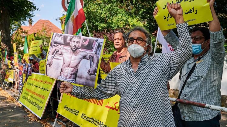 Demonstranten halten vor der Iranischen Botschaft in Berlin Bilder des hingerichteten Ringers Navid Afkari und demonstrieren lautstart gegen dessen Hinrichtungen im Irak.