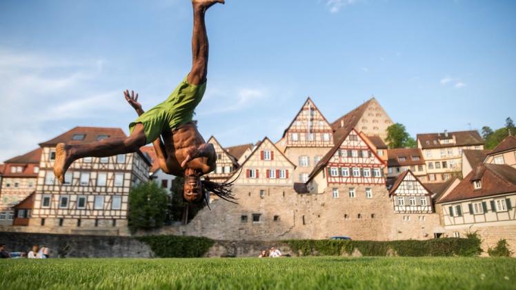 Capoeira-Trainer Formando Shock trainiert vor der Stadtkulisse in Baden-Württemberg, Schwäbisch Hall.