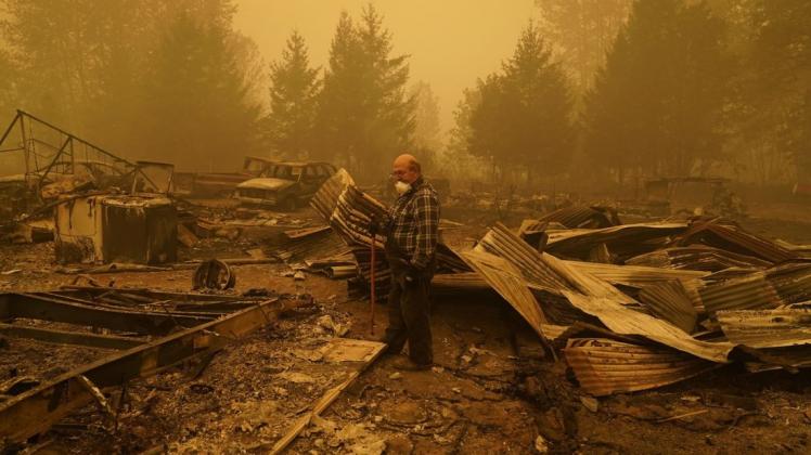 George Coble geht durch die Überreste seines Hauses im Bundesstaat Oregon, das durch einen Waldbrand zerstört wurde. George Coble geht durch die Überreste seines Hauses im Bundesstaat Oregon, das durch einen Waldbrand zerstört wurde.