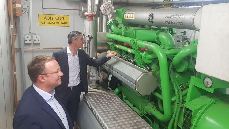 Auch dieser große Motor muss weichen, wenn die Avacon Natur zwei neue Blockheizkraftwerke anschafft. Das Bild zeigt Stephan Tenge, Vorstand der Avacon AG (rechts), mit Stuhrs Bürgermeister Stephan Korte.