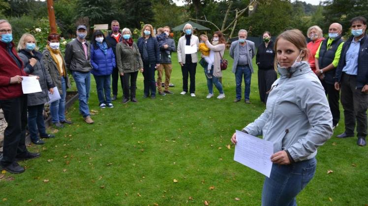 Anwohner und Politiker haben am Dienstagnachmittag im Garten von Wiebke Machel (mit Unterschriftenliste im Vordergrund) den Schulterschluss geübt.