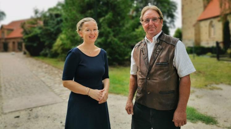 Pastorin Peggy Rotter und Bernd Anders, Kirchenältester und Mitglied des Bauausschusses, stehen auf der unsanierten Hälfte des Pfarrwegs in Lambrechtshagen.