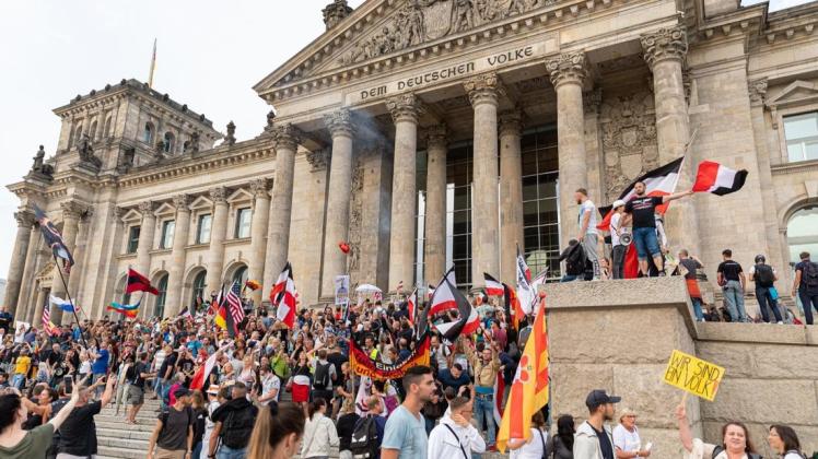 Das Bild des Anstoßes: Teilnehmer einer Kundgebung gegen die Corona-Maßnahmen stehen auf den Stufen zum Reichstagsgebäude, zahlreiche Reichsflaggen sind zu sehen.