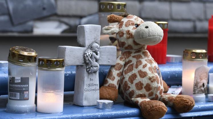 Ein Stofftier und Kerzen haben Mitmenschen vor dem Haus niedergelegt, wo die Polizei fünf Kindern tot gefunden hat.