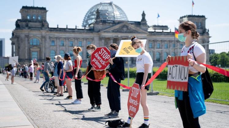 Gro´ße Koalition unter Druck:  Aktivisten demonstrieren mit einer Menschenkette und Plakaten vor dem Bundeskanzleramt gegen eine mögliche Abwrackprämie und für das Klima, während die Spitzen der Koalition über ein Konjunkturpaket und weitere Strategien im Kampf gegen das Coronavirus beraten.