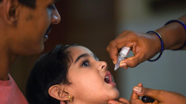 Ein Mädchen bekommt während der zweiten Phase einer Impfkampagne Tropfen gegen Kinderlähmung.