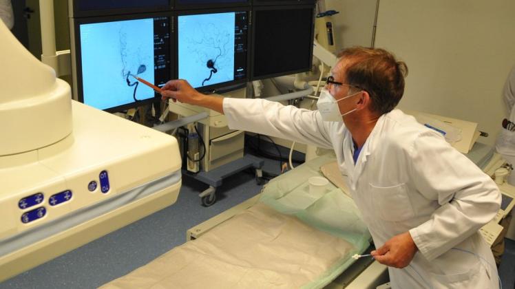 Chefarzt Walter Möller-Hartmann (Radiologie und Neuroradiologie) zeigt den Arterienverschluss im Gehirn.