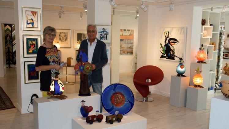 Peter und Hannelore de Hoogd vor einigen der farbenfrohen Werke der Glasmanufaktur Borowski, die zum ersten Mal in einer Sommer-Sonderausstellung bei Atelierspuren präsentiert wurden.