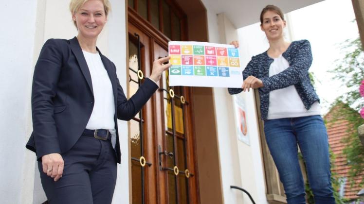Setzen sich für ein Nachhaltigkeitskonzept der Gemeinde ein: Bürgermeisterin Annette Große-Heitmeyer (links) und Klimaschutzmanagerin Franziska Müller. Die Bundesregierung hat in ihrem Konzept 17 Ziele formuliert, die auf dem Schaubild zu sehen sind.