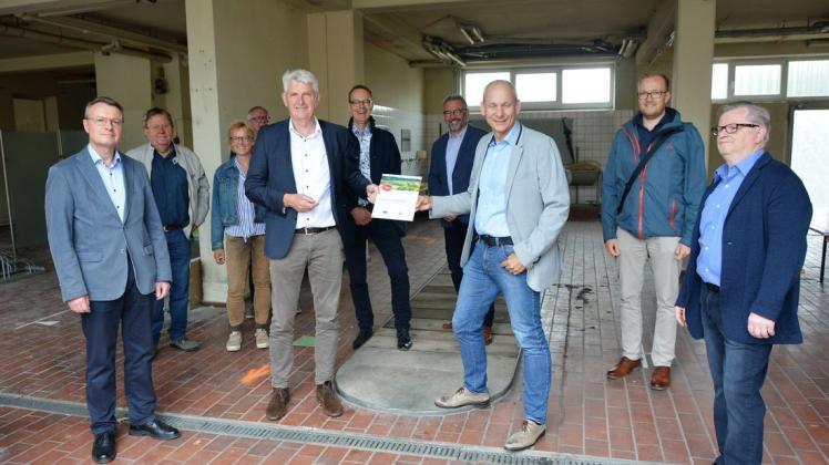 Bürgermeister Heiner Pahlmann erhielt vor geladenen Gästen von Uwe-Heinz Bendig zum Abschluss der Bewilligung der Fördergelder für den Umbau des alten Feuerwehrhauses zum Dorftreff Engter eine Plakette ausgehändigt.