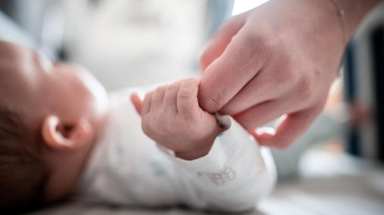 Ein Baby klammert sich an den Finger seiner Mutter. Frauen in Deutschland haben im Jahr 2019 weniger Babys auf die Welt gebracht als 2018.